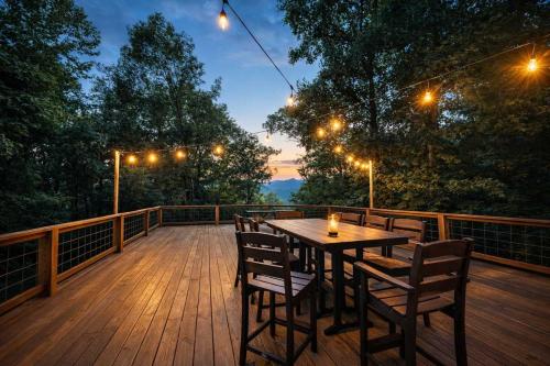 a wooden deck with a wooden table and chairs at Happy Top Hideaway in Bryson City