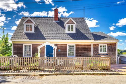 una casa con una staccionata di legno davanti di Elegant home right in town with gorgeous water view, deck & interior a Wiscasset