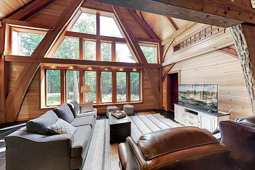 a large living room with a couch and a tv at 2 beautifully designed, off-the-grid homes with amazing lakefront views & access in Franklin