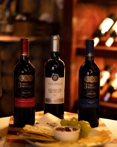 two bottles of wine sitting on a table with grapes at Las Cabañitas, el boqueron in San Salvador