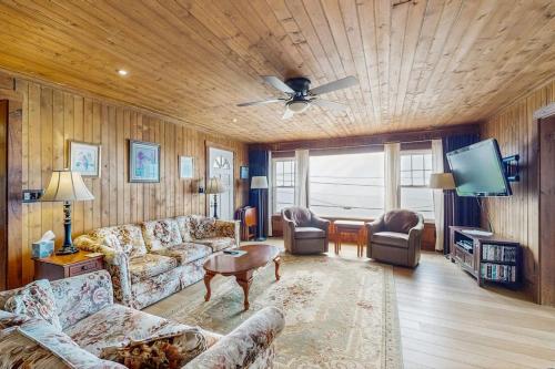 a living room with a couch and a ceiling fan at Dog-friendly, bayfront home - gorgeous ocean views, private balcony & fireplace in East Boothbay