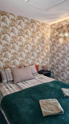 a bedroom with a large bed with a green blanket at ''Ābeļdārza māja'' in Āboliņi