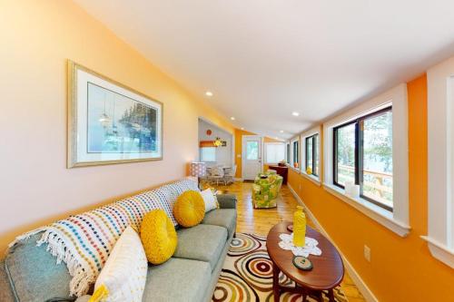 a living room with a couch and a table at Waterfront home on St George River with private beach & deck - near festivals in Cushing