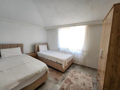 a small bedroom with two beds and a window at kozalak evleri in Gökbel