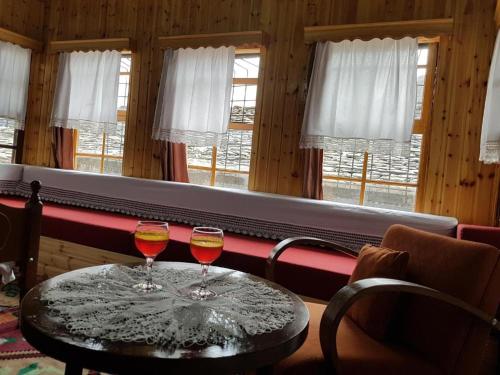 two wine glasses on a table in front of a window at AmedaPm in Gjirokastër