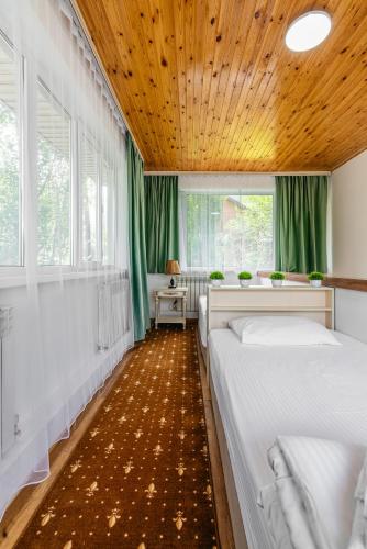 a bedroom with two beds and a wooden ceiling at Tau Shyraq in Almaty