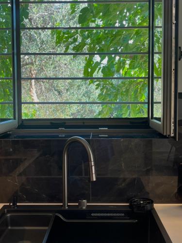 a kitchen sink with a window above a kitchen counter at Bella Villa in Proástion
