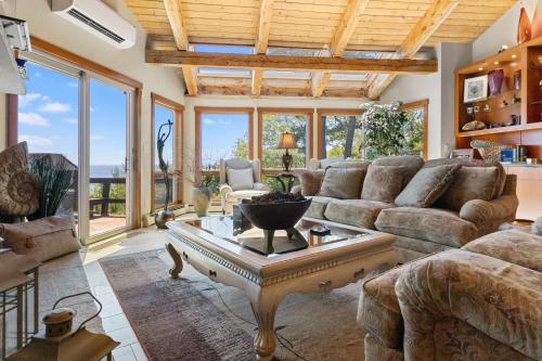 a living room with a couch and a table at Elegant ocean view home with breathtaking views, private hot tub & large deck in Rockport