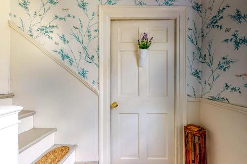 a white door with a vase of flowers on the wall at Lovely studio w/full kitchen/free WiFi- next to river/antique shops/restaurants in Wiscasset