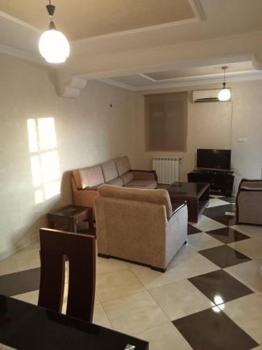 a living room with couches and a checkered floor at Duplex pres de la mer a Alger in Rouiba