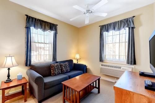a living room with a blue couch and two windows at Cozy & Clean Second-Story Suite w/ Kitchenette & Free WiFi - Walk to the Harbor in Northeast Harbor