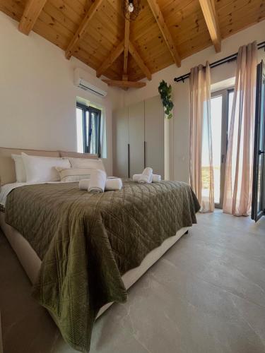 a bedroom with a large bed in a room with windows at Bella Villa in Proástion