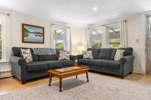 a living room with two couches and a coffee table at Bright, spacious getaway with full kitchen, furnished porch & WiFi - near trails in Seal Harbor