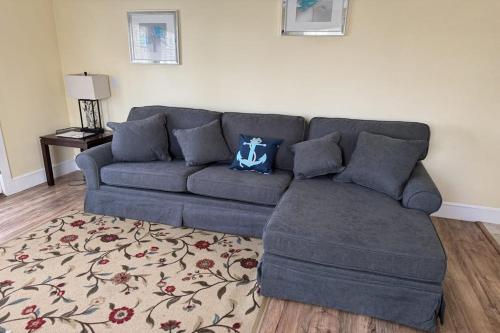 a blue couch in a living room with a rug at New Riverfront Condo in Sheepscot Harbour - Walk to Famed Seafood Eatery in Edgecomb