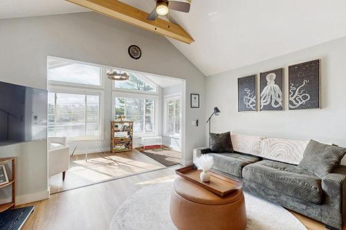 a living room with a couch and a fireplace at Charming cottage with a spacious deck overlooking the Megunticook River in Camden