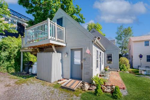 a small house with a balcony on top of it at Downtown, ground floor studio near the ocean w/patio, outdoor dining area & more in Wiscasset