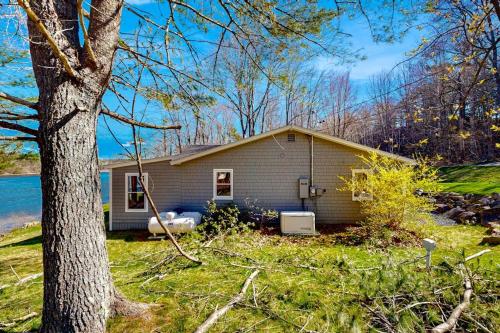 a small house with a tree in front of it at Gorgeous Waterfront Home on Westport Island with 2 Sunrooms in Montsweag