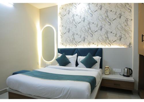 a bedroom with a large bed with a painting on the wall at Shree Sanmat Guest House in Gwalior