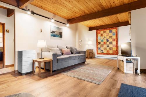 a living room with a couch and a television at Beautiful hidden Waterfront Retreat with Rocky Beach in Boothbay
