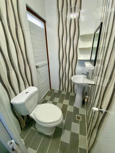a bathroom with a toilet and a sink at Hermosa Traveler's Corner in Culis