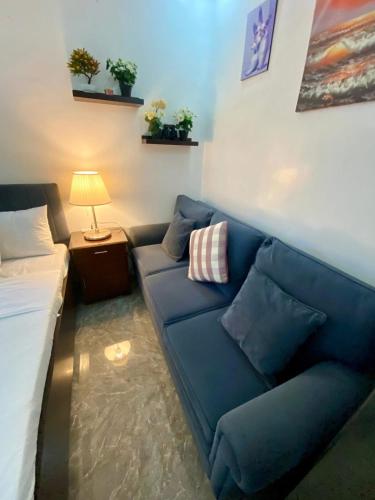 a living room with a blue couch and a bed at Hermosa Traveler's Corner in Culis