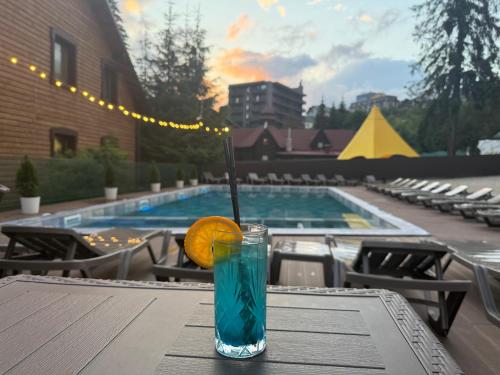 a drink sitting on a table next to a pool at Madison in Bukovel