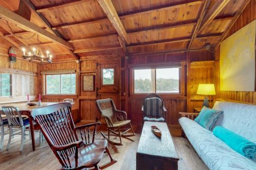 a living room with a couch and a table at Waterfront cabin with ocean view & private dock in East Boothbay