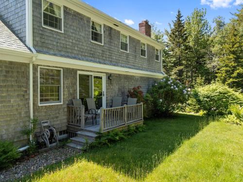 a house with a porch with chairs on it at Dog-friendly oceanfront home with private shorefront, two fireplaces, & firepit in Steuben