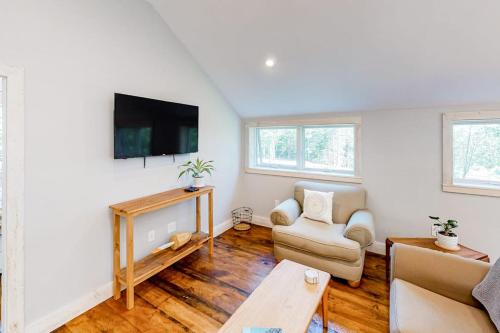 a living room with a couch and a tv at Contemporary home with woodstove, firepit, 2 kitchens & fast WiFi- walk to beach in Marlboro