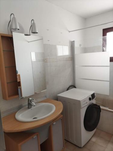 a bathroom with a sink and a washing machine at Maison 80 m2 - proche des plages in Montpellier