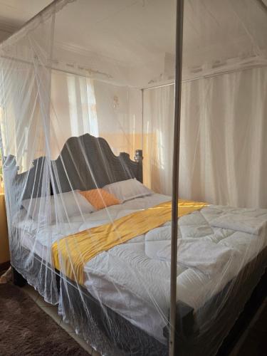 a bed with a canopy in a bedroom at Rose Petals in Sagana