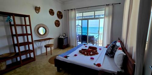 a bedroom with a bed with a view of the ocean at Equalia boutique hotel in Jambiani