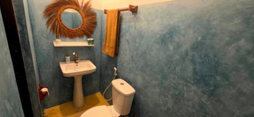 a bathroom with a sink and a toilet and a mirror at Equalia boutique hotel in Jambiani