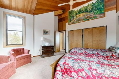 a bedroom with a bed and a chair and a window at Private Oceanfront Home -- 2 Fireplaces, 4 Decks & Grill, Dog-friendly in East Boothbay