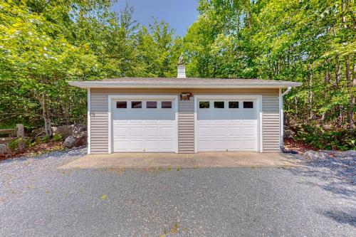 a white garage with a roof on a driveway at Inviting dog-friendly home with firepit & Ping-Pong - near Acadia National Park in Ellsworth