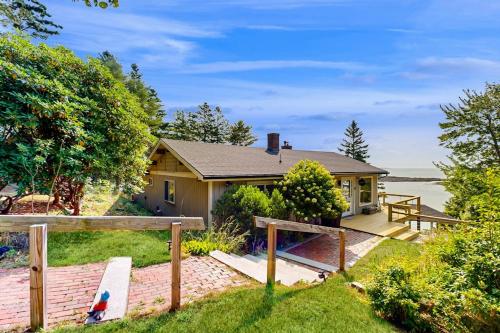 a house with a fence in front of it at Stunning artist's retreat with ocean view & amazing deck, near Reid State Park in Georgetown