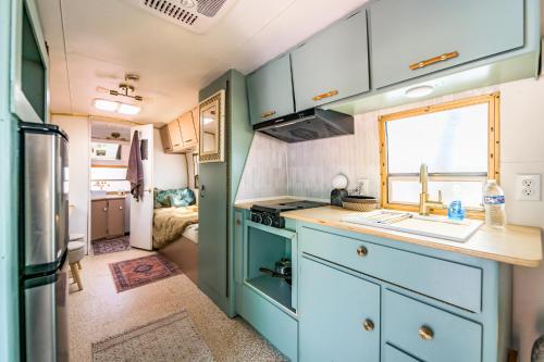 an rv kitchen with blue cabinets and a sink at Ponderosa Pines Resort in Parks