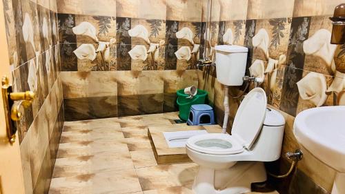 a bathroom with a toilet and a sink at The Al-Maaz Guest House in Murree