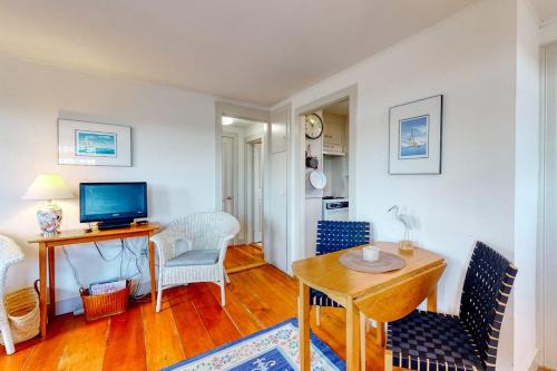 a living room with a table and chairs and a television at Lovely studio w/full kitchen/free WiFi- next to river/antique shops/restaurants in Wiscasset
