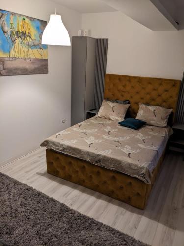 a bedroom with a large bed with a brown headboard at Bran' s in Constanţa