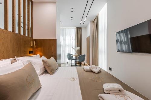 a hotel room with a large bed with towels on it at Via Mare Jacuzzi Suites by PS in Durrës