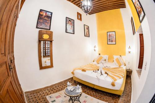 a bedroom with a bed and a table in a room at Dar Mayssa Fez in Fez