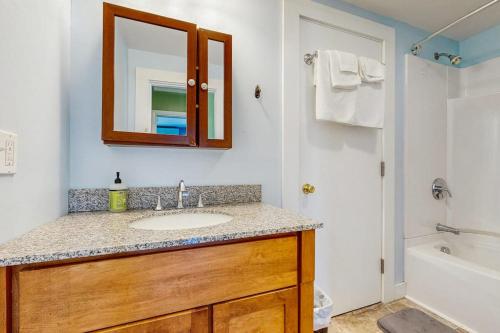 a bathroom with a sink and a mirror and a tub at Dog-Friendly House with WiFi and Deck - Near the Water, Eateries, and Shopping in Bar Harbor