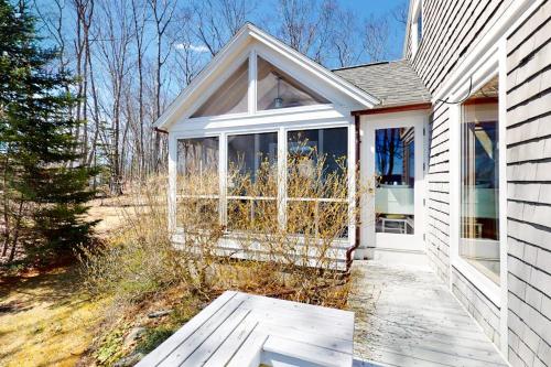 a white house with a white door and windows at Oceanfront retreat with sunrise views, screened porch, & deck in Blue Hill