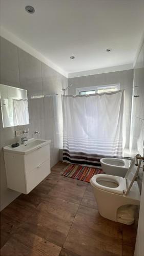 a bathroom with a toilet and a sink at Kanoo Lodge in Tigre