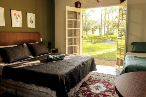 a bedroom with a bed and a sliding glass door at Private Suite with Kitchen & Pool Access in Itapetininga