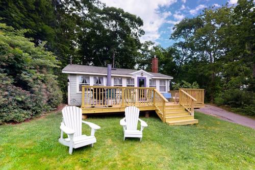 a large deck with two chairs and a house at Dog-friendly Fisher Hill home with patio and wood stove - walk to the harbor in Boothbay Harbor