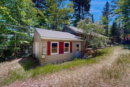 a small house in the middle of a field at Lady Slipper Cottage: Charming Lakefront Retreat with Canoes, Kayaks, and Modern Comforts in Somesville