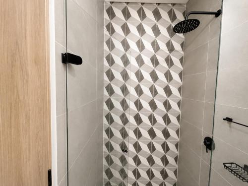 a bathroom with a shower with a tiled wall at Apartaestudio Centro Internacional UTEK in Bogotá