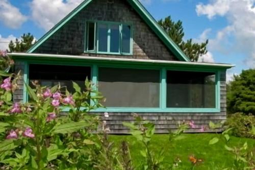 a house with a window on the side of it at Peaceful coastal cabin with screened porch, water view of the cove, dog-friendly in Owls Head